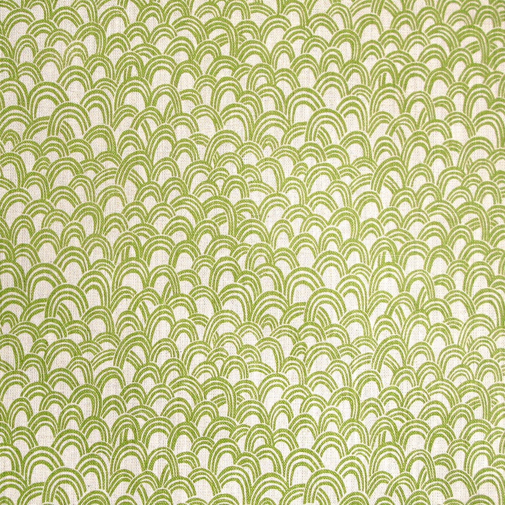 Detail of fabric in a playful repeating hoop pattern in light green on a cream field.