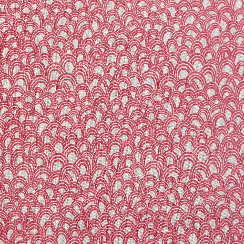 Detail of fabric in a playful repeating hoop pattern in pink on a cream field.