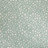 Detail of fabric in a playful repeating hoop pattern in turquoise on a cream field.