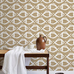 A bench with a towel and clay vases stands in front of a wall papered in a playful fish print in white and light brown.