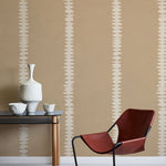 Modern interior with a red chair, table, and decorative items against a beige wall with white stripe pattern. 