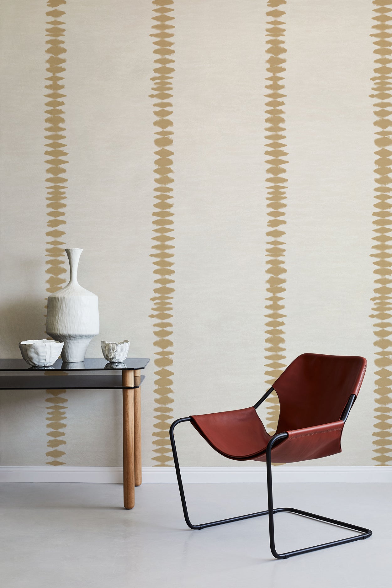 Modern red chair and table against a wall with decorative striped pattern