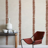 Modern interior with a red chair, black table, and decorative vase against a wall with abstract brown stripe