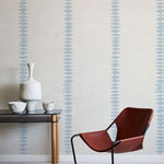 Modern brown chair and table against a wall with decorative blue stripes