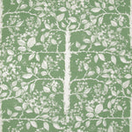 Detail of fabric in a large-scale tree and leaf print in cream on a green field.