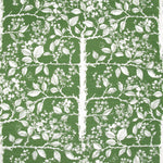 Detail of fabric in a large-scale tree and leaf print in cream on a green field.