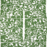 Detail of fabric in a large-scale tree and leaf print in cream on a green field.