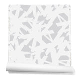 Partially unrolled roll of wallpaper in a bold white brushtroke pattern on a light gray background.