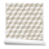 Partially unrolled wallpaper in a hand-painted tumbling block pattern in shades of beige on a white background.