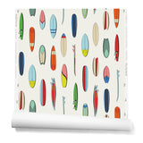 A roll of wallpaper with a pattern of illustrated surfboards in a variety of bright neon and primary colors on a cream background.