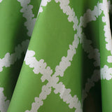 Draped fabric yardage in a floral grid print in white on a green field.