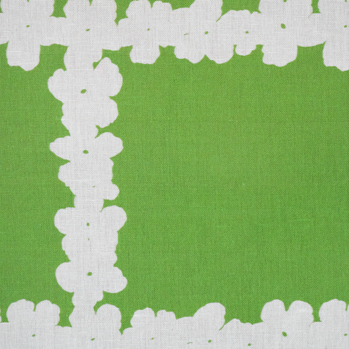 Detail of fabric in a floral grid print in white on a green field.