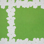 Detail of fabric in a floral grid print in white on a green field.