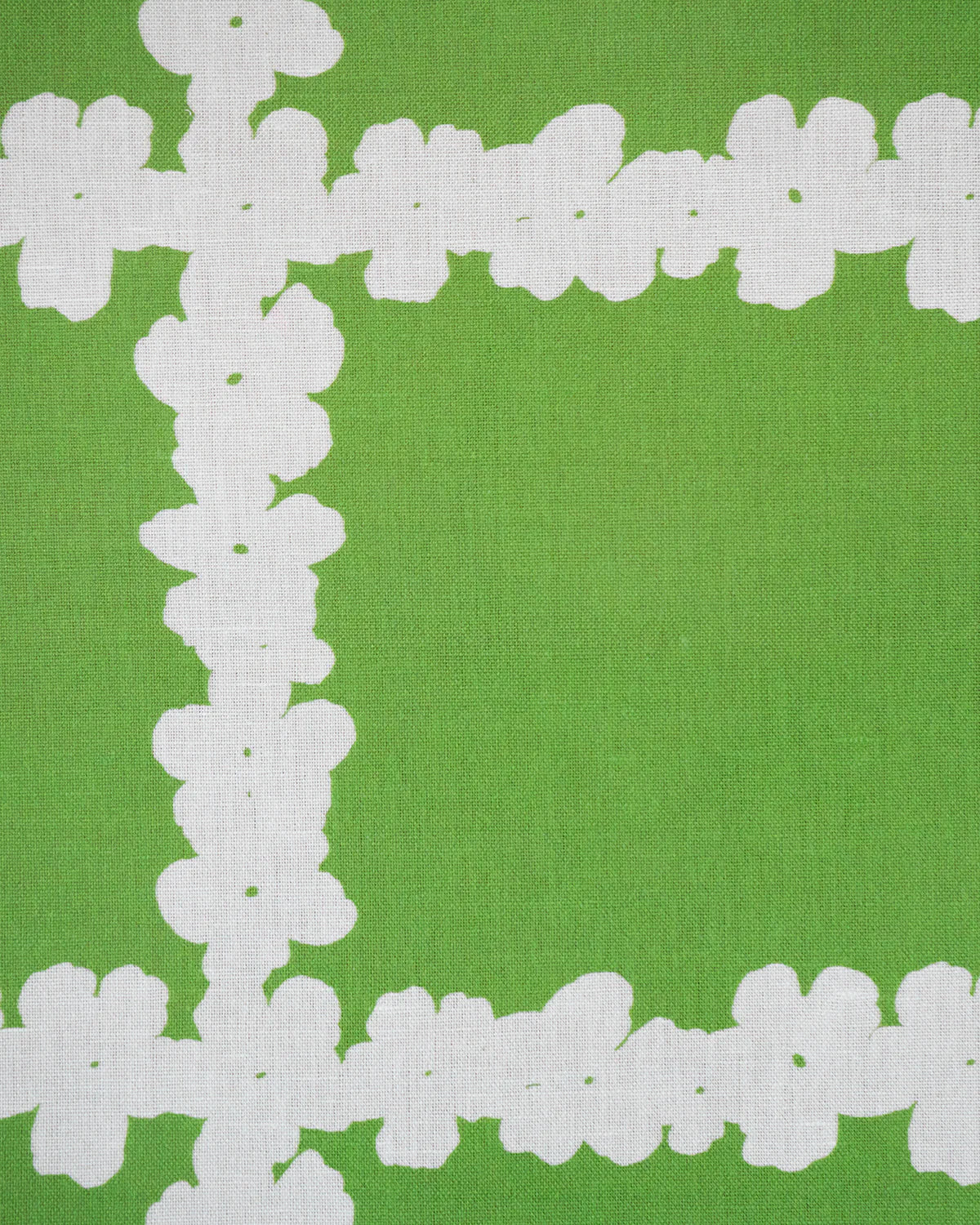 Detail of fabric in a floral grid print in white on a green field.