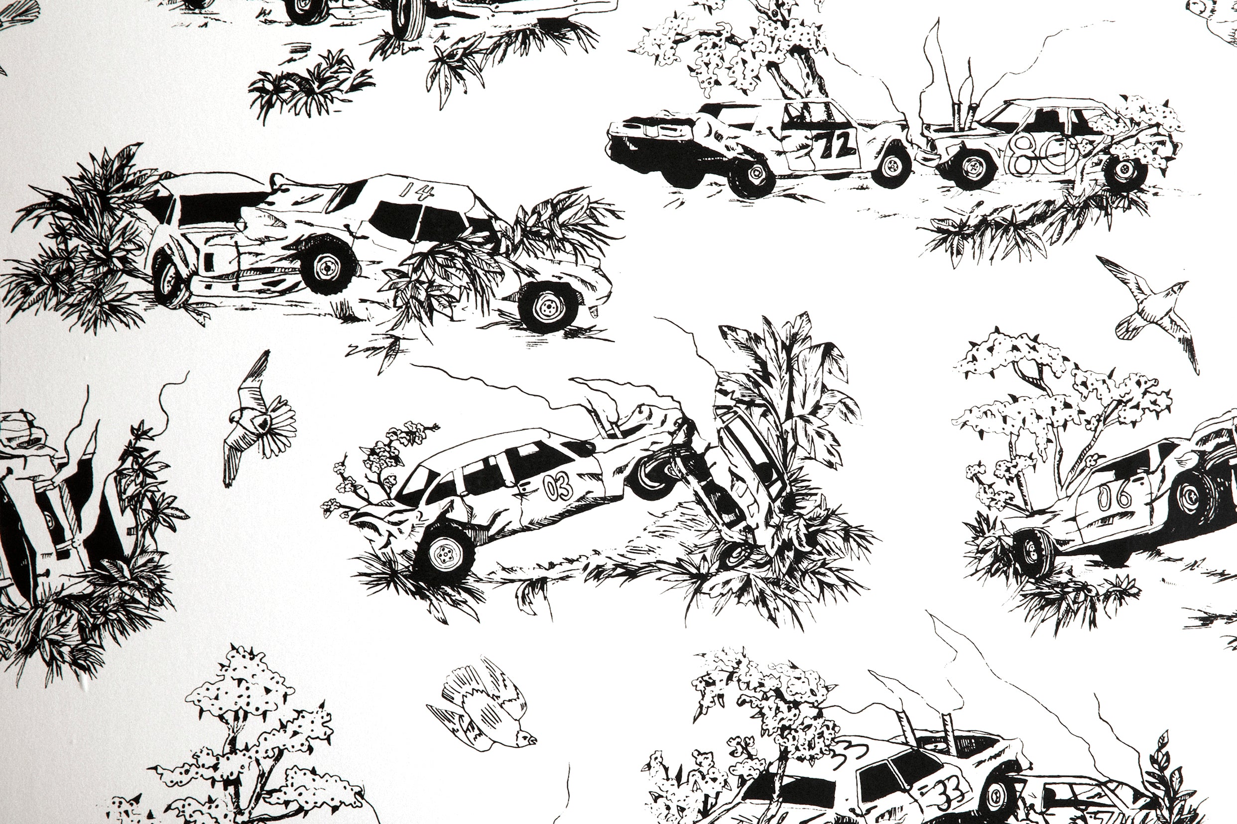 A vase of flowers stands in front of a wall covered in a playful illustrated car crash print in black on a white field.