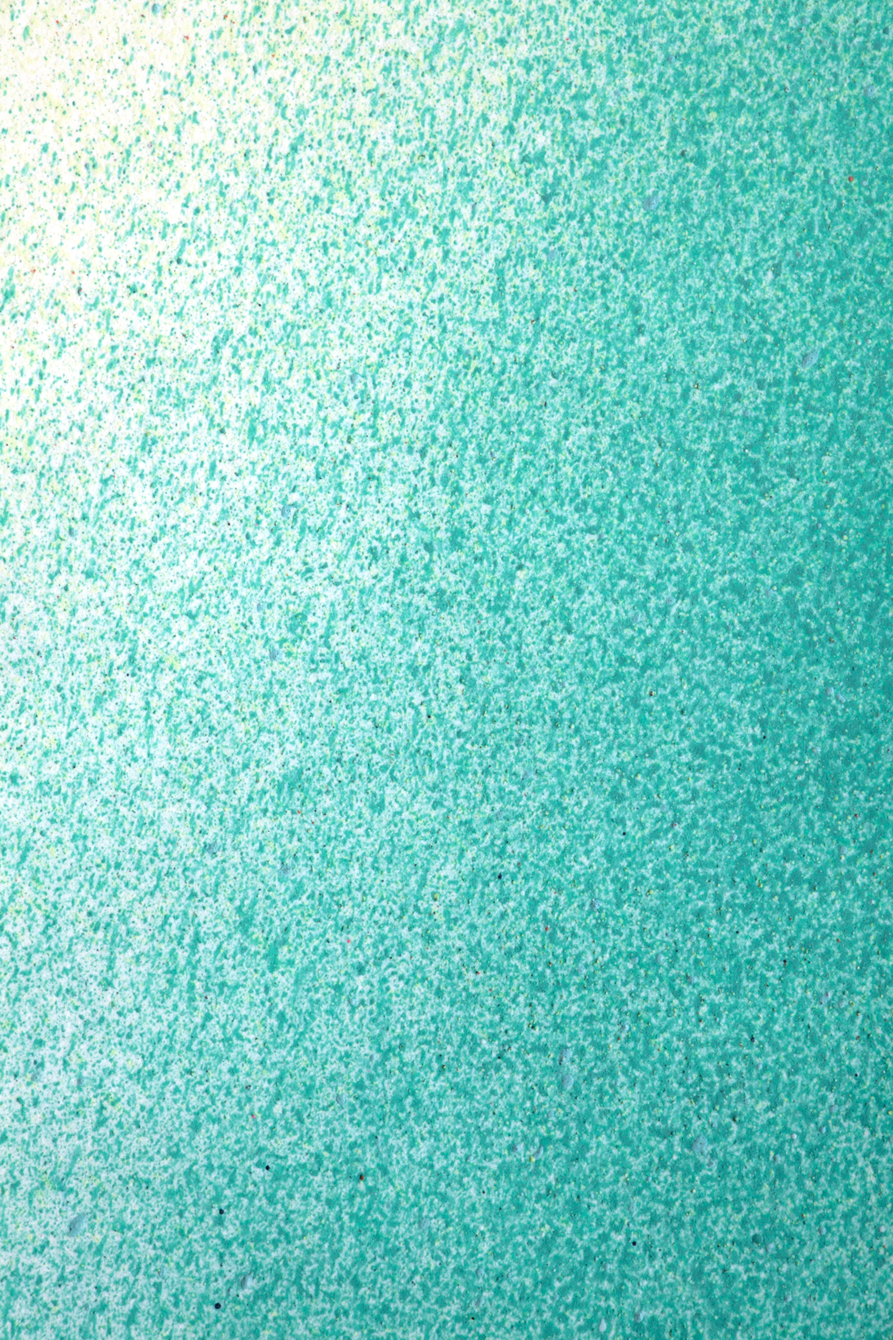 Close up of paint splatters in green and turquoise.