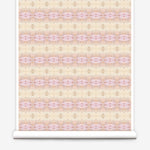 Partially unrolled wallpaper yardage in a gridded paint splatter print in shades of pink, yellow, cream and white.