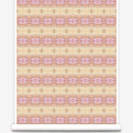 Partially unrolled wallpaper yardage in a gridded paint splatter print in shades of pink, orange, yellow and white.