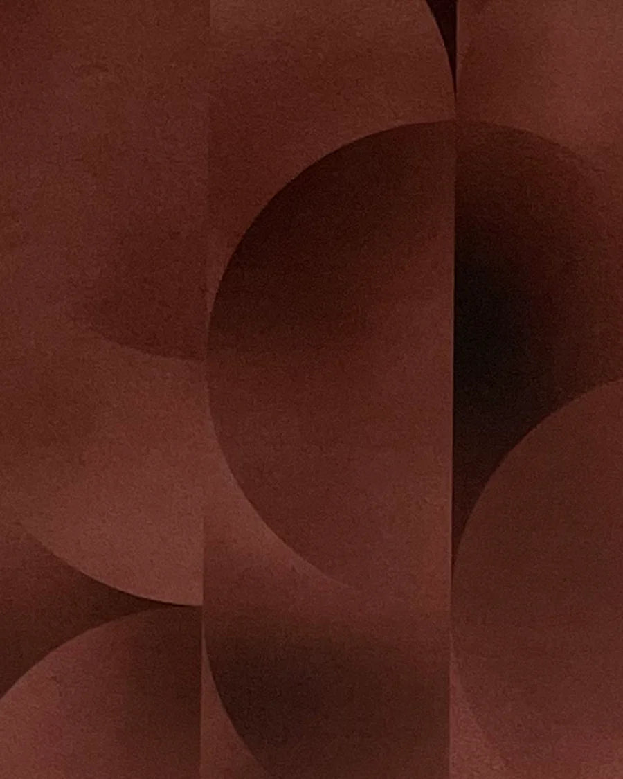 Detail of wallpaper in an abstract curvilinear print in mottled brown and red.