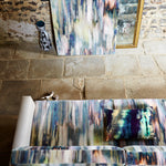 Overhead shot of a living space with a sofa and accent wall both covered in the same abstract painterly print.