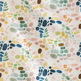 Detail of fabric in a playful paint blotch print in shades of blue, yellow and pink on a cream field.