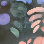 Detail of wallpaper in a playful paint blotch print in shades of blue, green and pink on a black field.