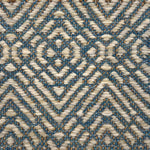 Textural flatweave rug in a raised diamond design in cream on a turquoise field.