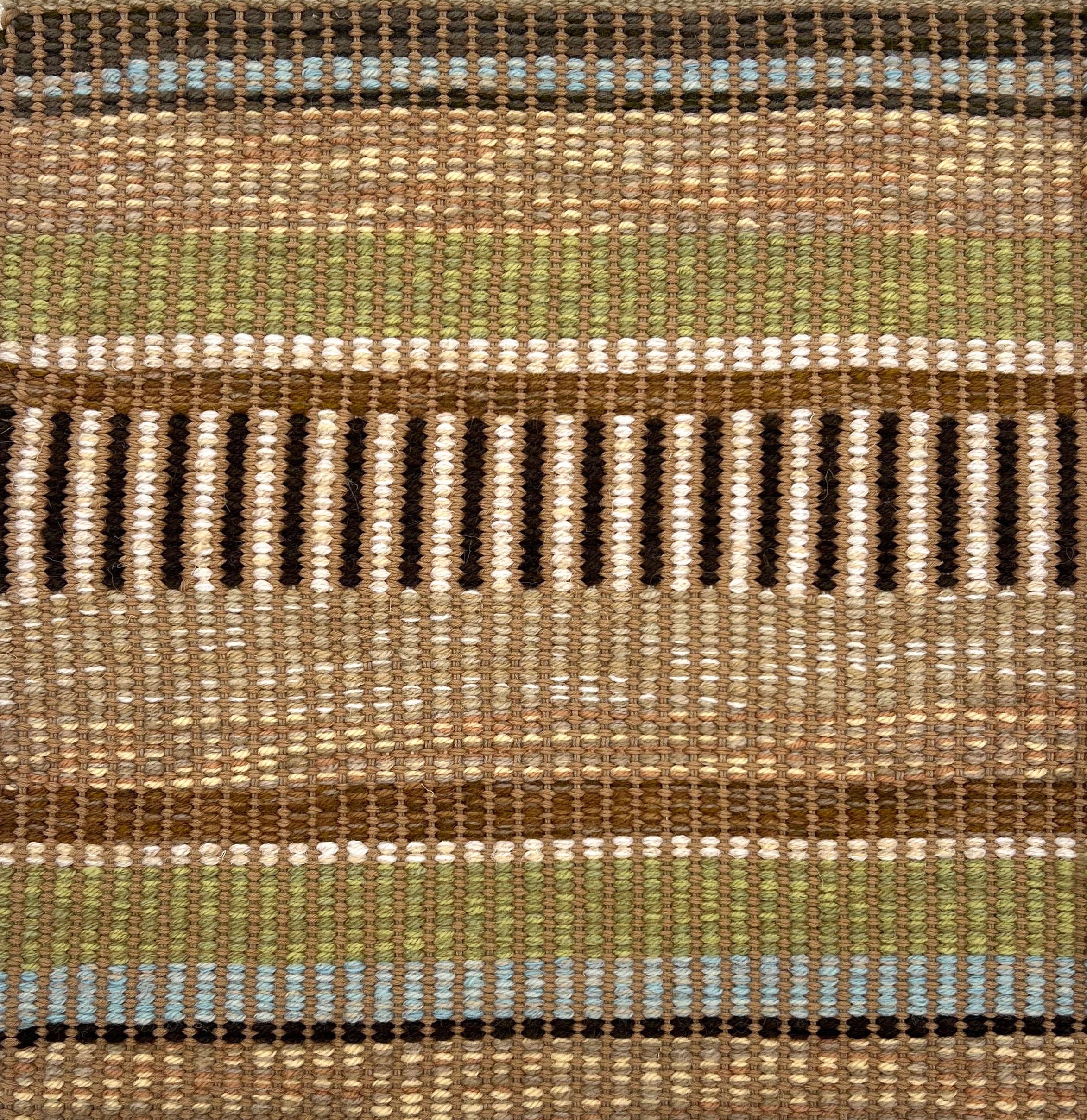 Textural flatweave rug in a varigated stripe in brown, tan, cream, green and blue.