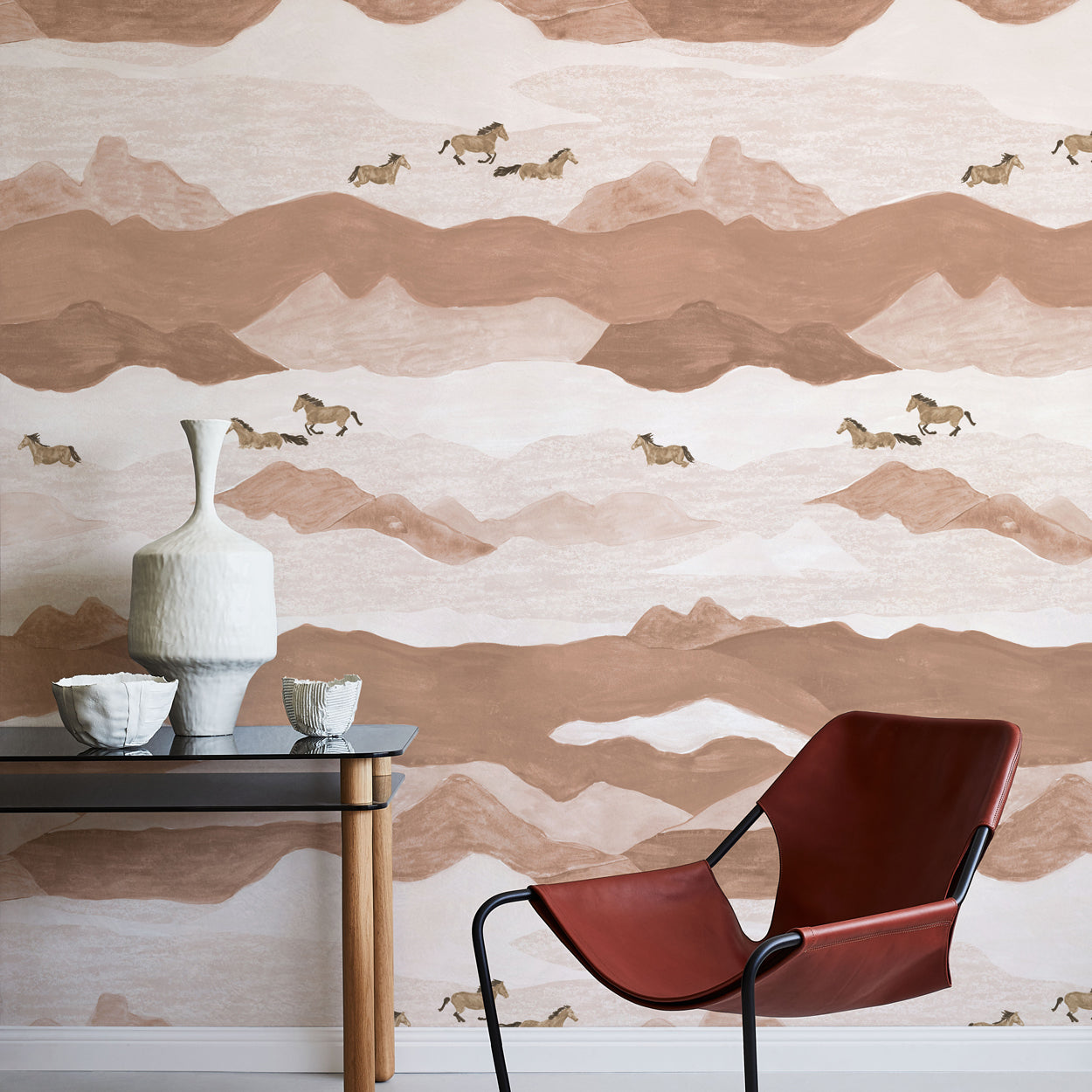 Modern interior with a brown and beige mountain-patterned wall, a red chair, and a small table with decorative items.