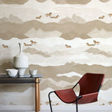 Modern interior with a red chair, table, and decorative items against a mountain-themed wallpaper.