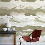Modern interior with a red chair and table against a mountain and horse wallpaper.