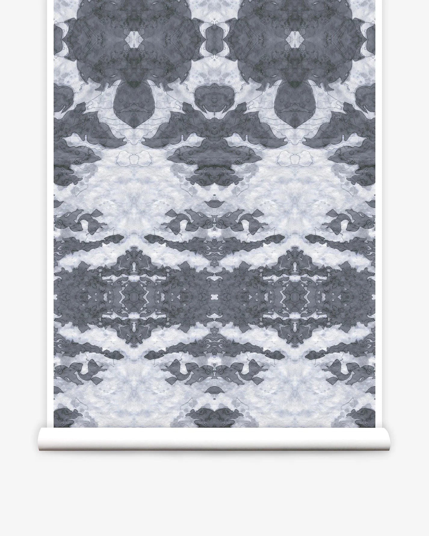 Partially unrolled wallpaper yardage in a painterly ikat print in shades of gray and light blue.