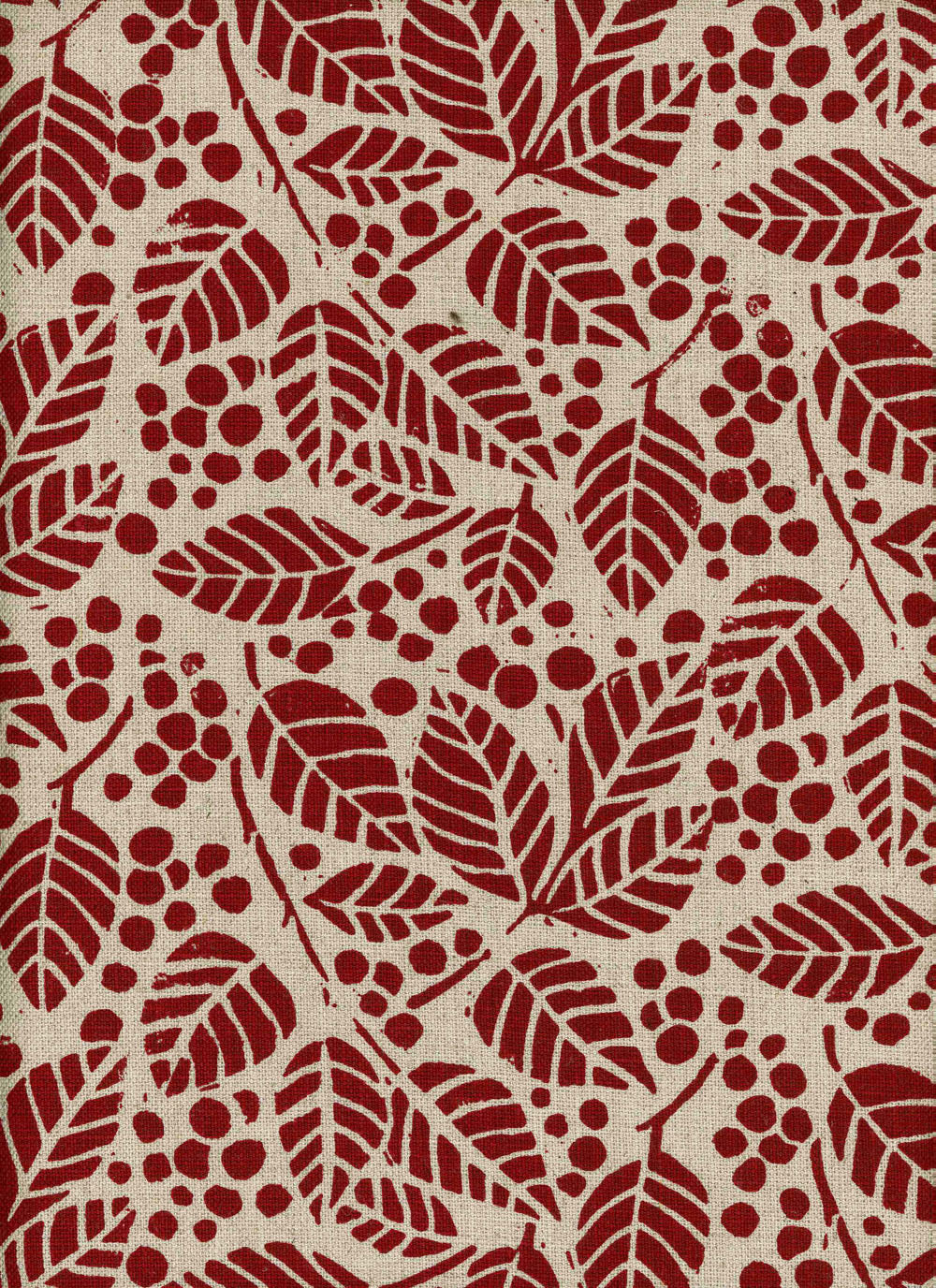 Detail of fabric in a repeating leaf print in red on a tan field.