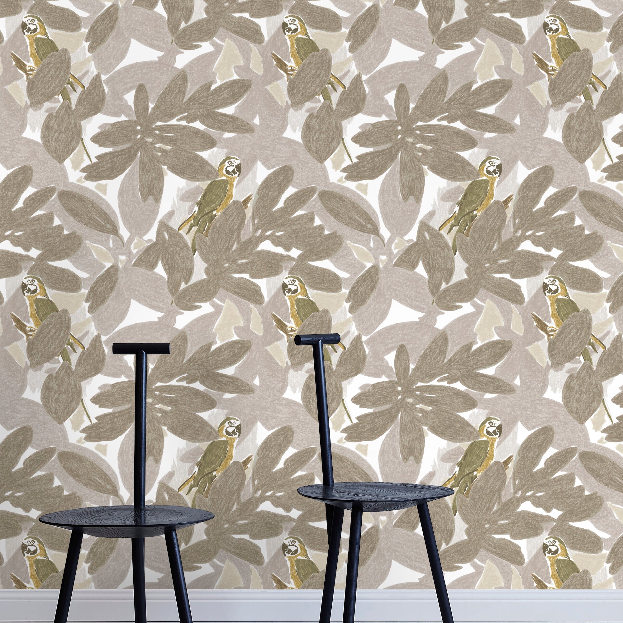 Two minimalist black chairs stand in front of a wall papered in a botanical and parrot print in gray, brown and yellow.