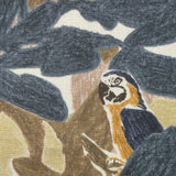 Close-up of fabric in a playful botanical and parrot print in shades of blue, brown and yellow on a white field.