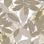 Detail of fabric in a playful botanical and parrot print in shades of gray, brown and yellow on a white field.