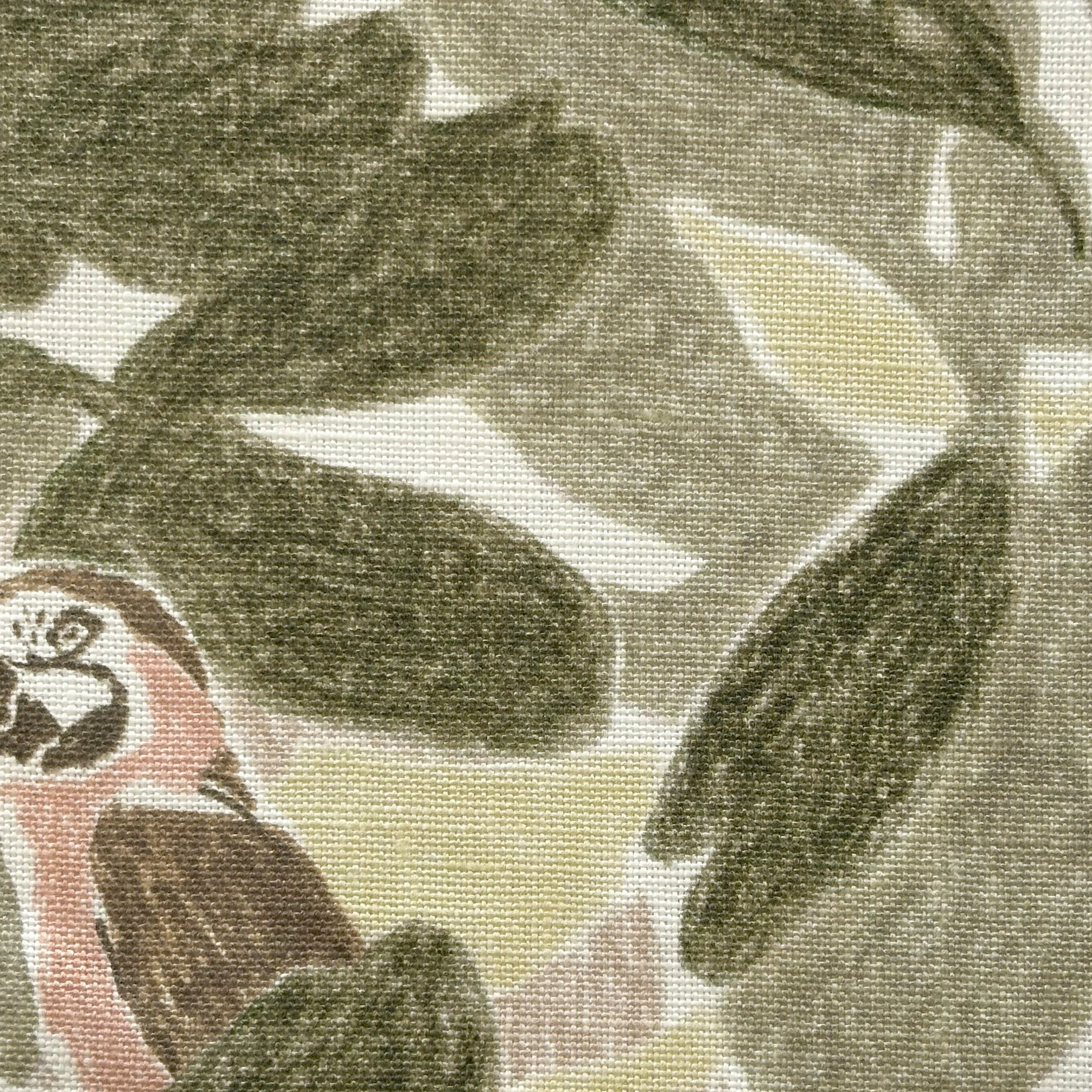 Close-up of fabric in a playful botanical and parrot print in shades of green, brown and pink on a white field.