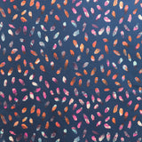 Detail of fabric in a playful paint blotch print in shades of pink, blue and orange on a navy field.