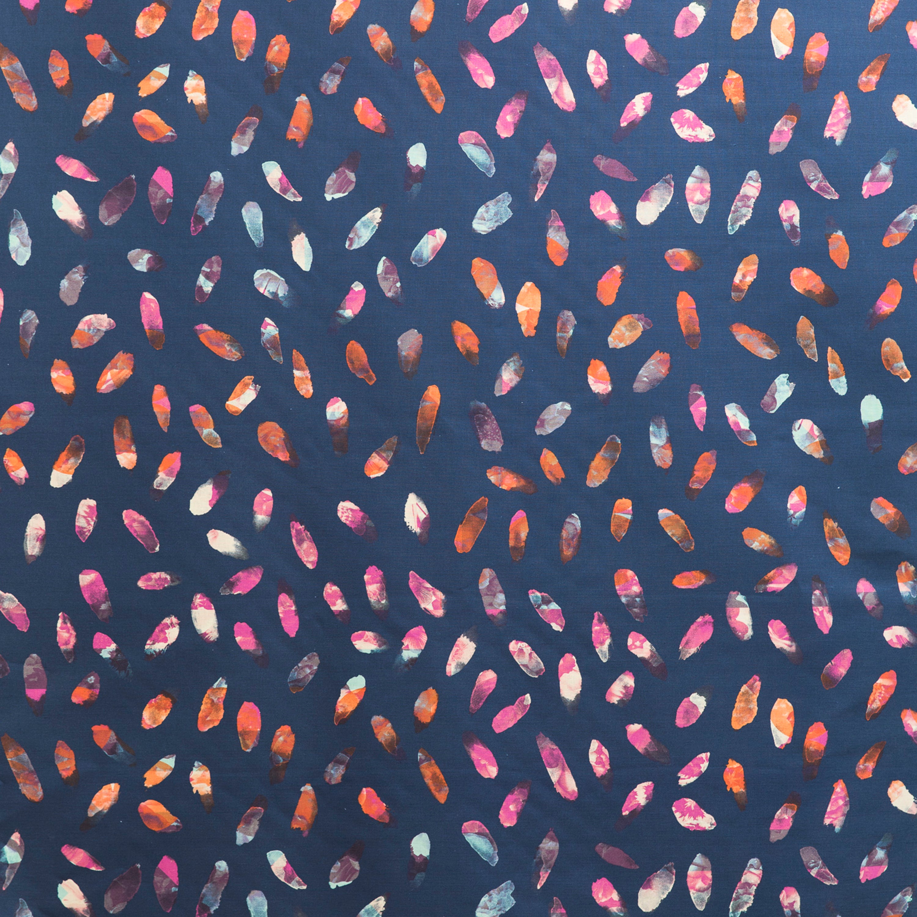 Detail of fabric in a playful paint blotch print in shades of pink, blue and orange on a navy field.