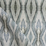 Draped fabric yardage in an abstract diamond print in shades of gray and navy on a cream field.