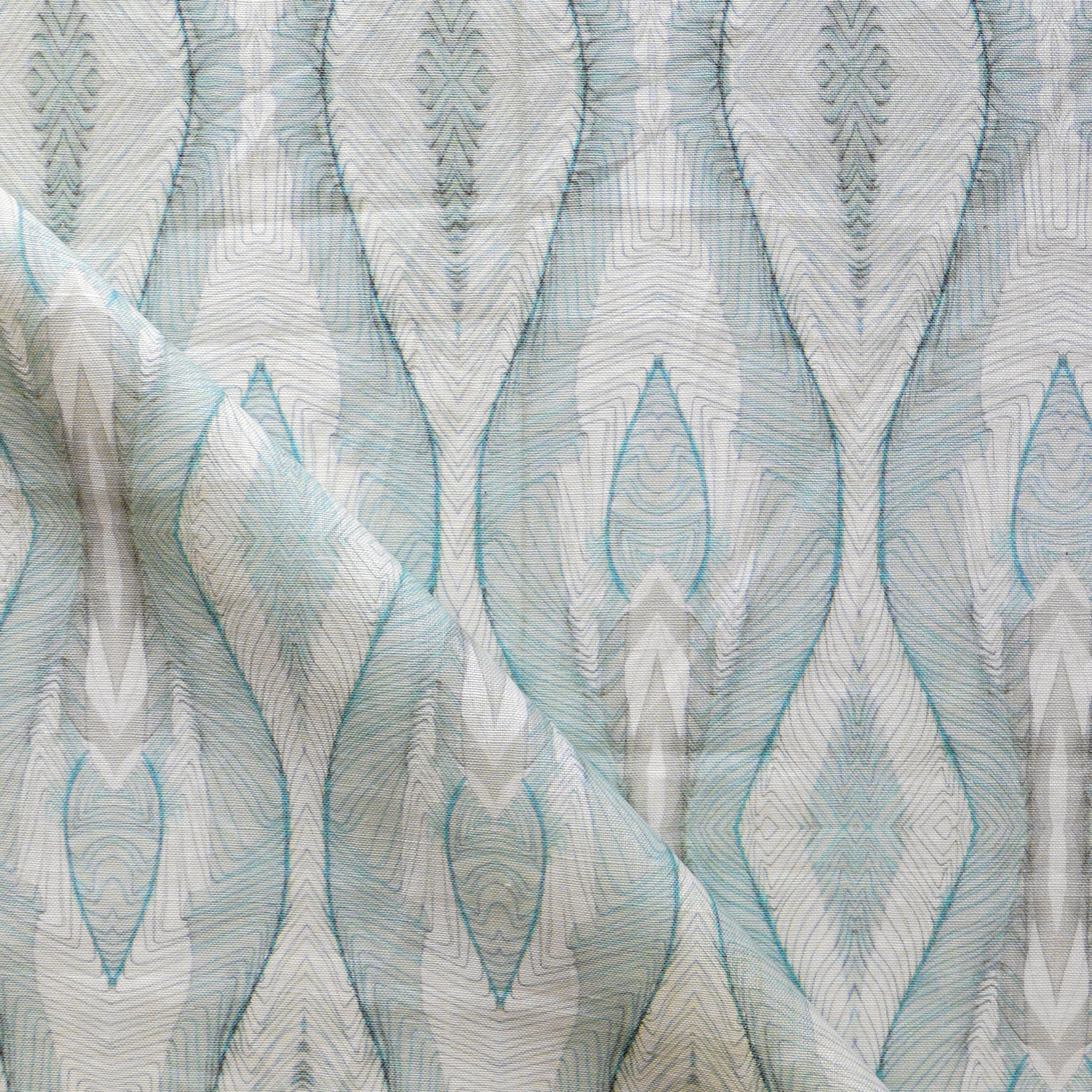 Draped fabric yardage in an abstract diamond print in shades of gray and blue on a cream field.