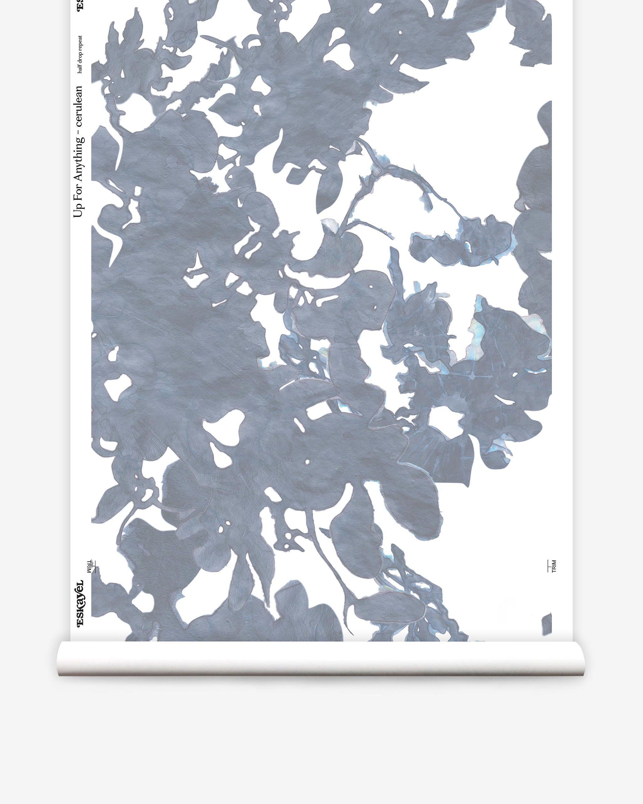 Partially unrolled wallpaper yardage in an abstract floral print in shades of gray and blue on a white field.