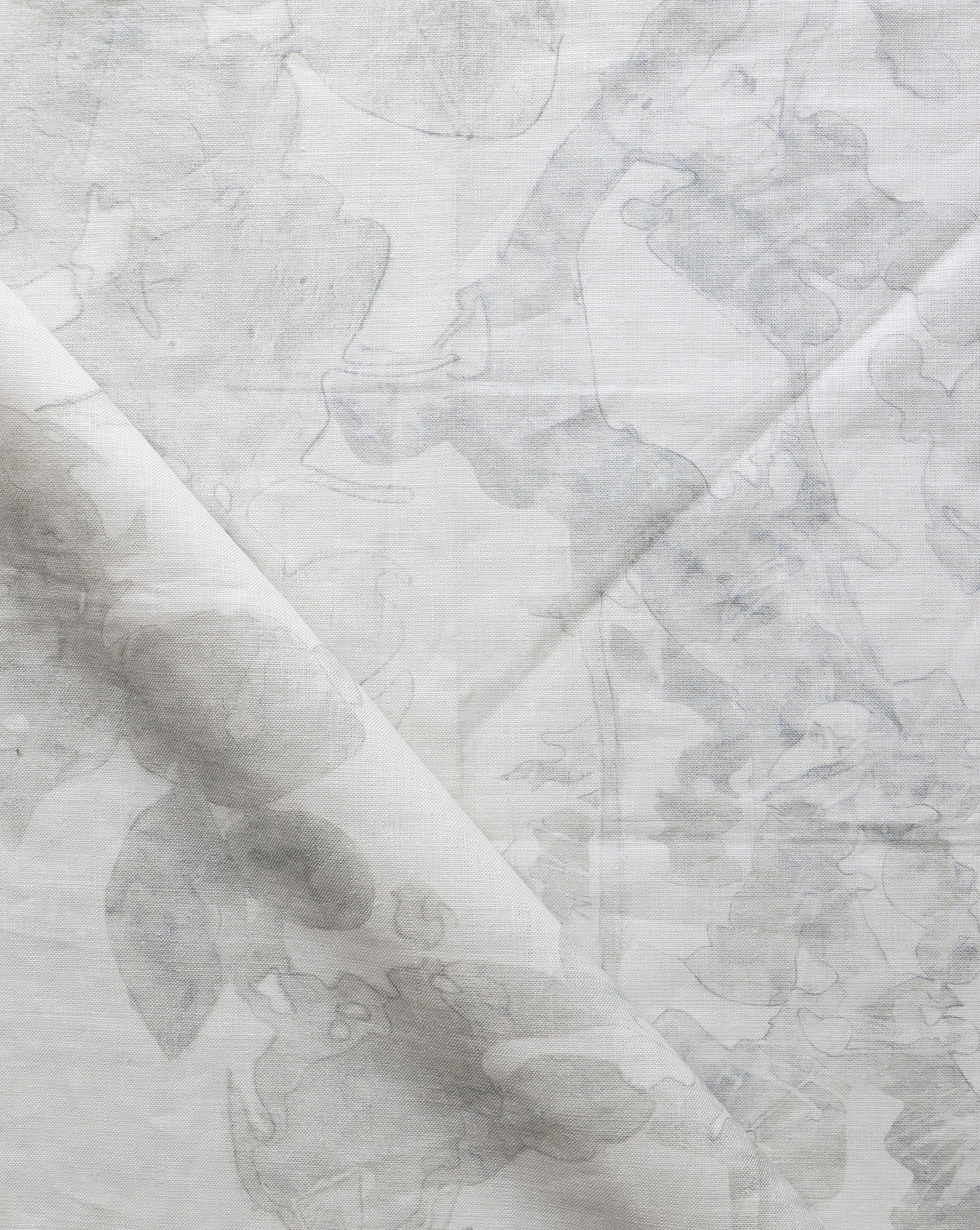 Draped fabric yardage in an abstract botanical print in shades of gray on a cream field.