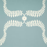 Detail of wallpaper in a leafy lattice print in cream on a light blue field.