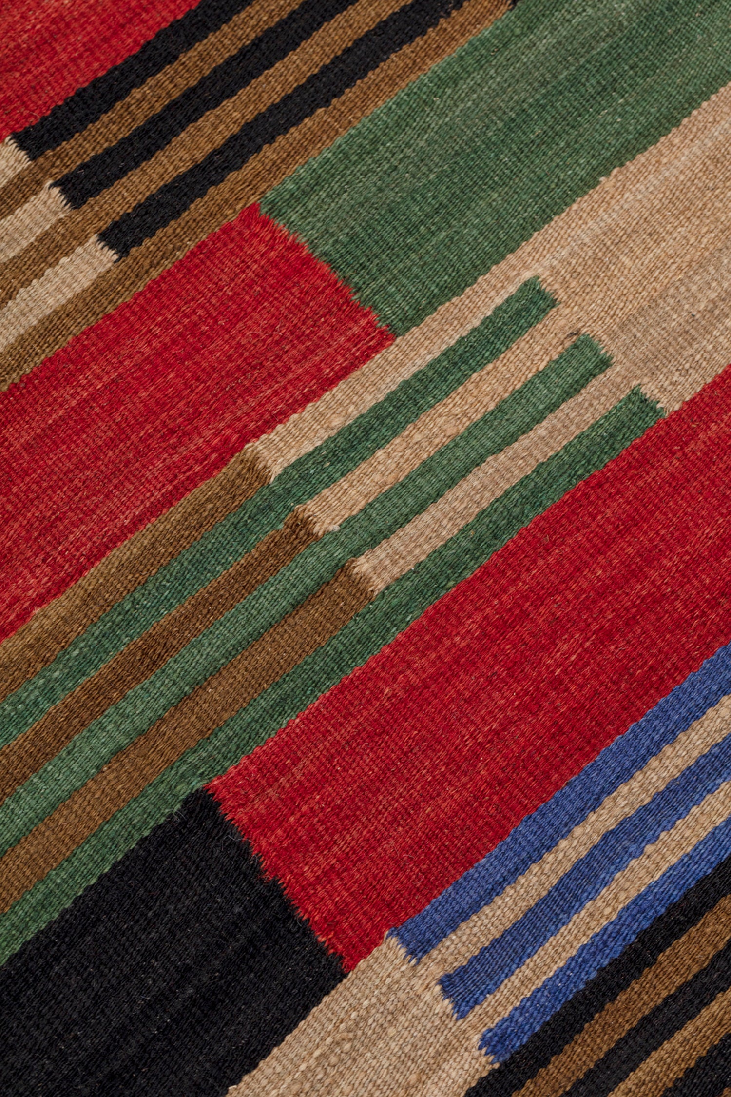 Detail of a handwoven runner in a stacked stripe pattern in blue, red, green , tan and black.