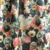 Draped fabric yardage in a dense photorealistic floral print in shades of pink, green and black.