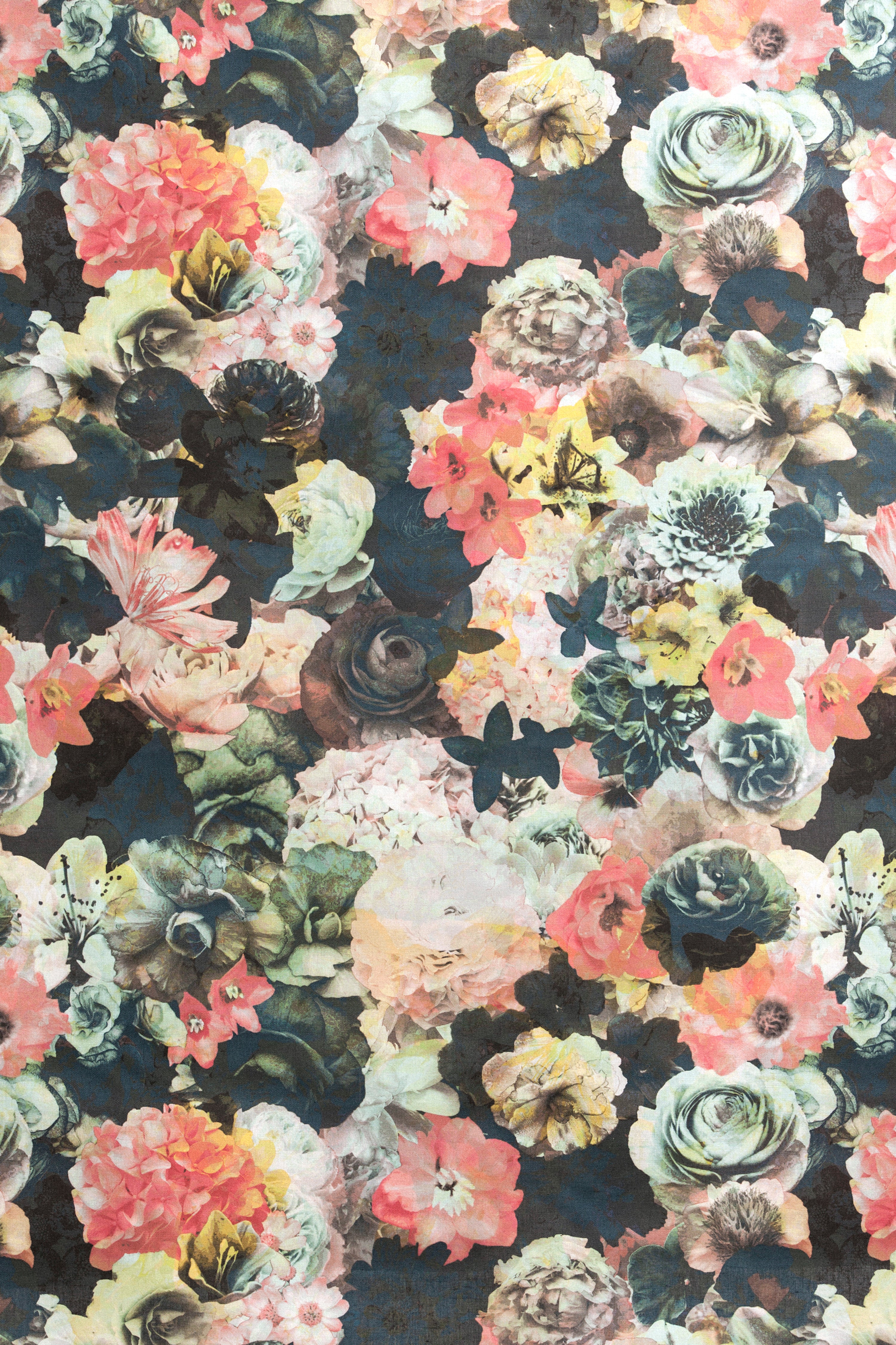 Detail of fabric in a dense photorealistic floral print in shades of pink, green and black.