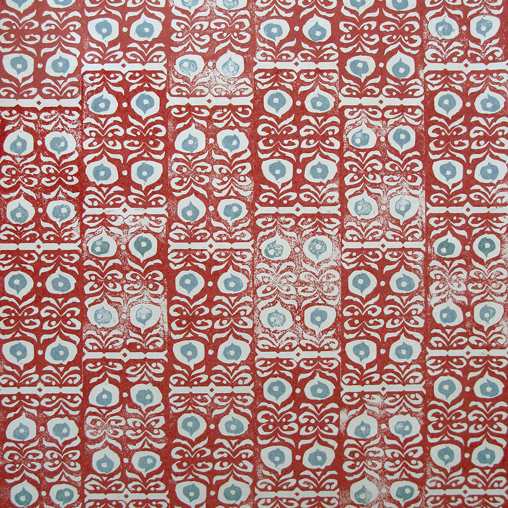 Wallpaper in a repeating damask print in light blue and white on a red field.