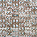 Wallpaper in a repeating damask print in blue and white on a brown field.