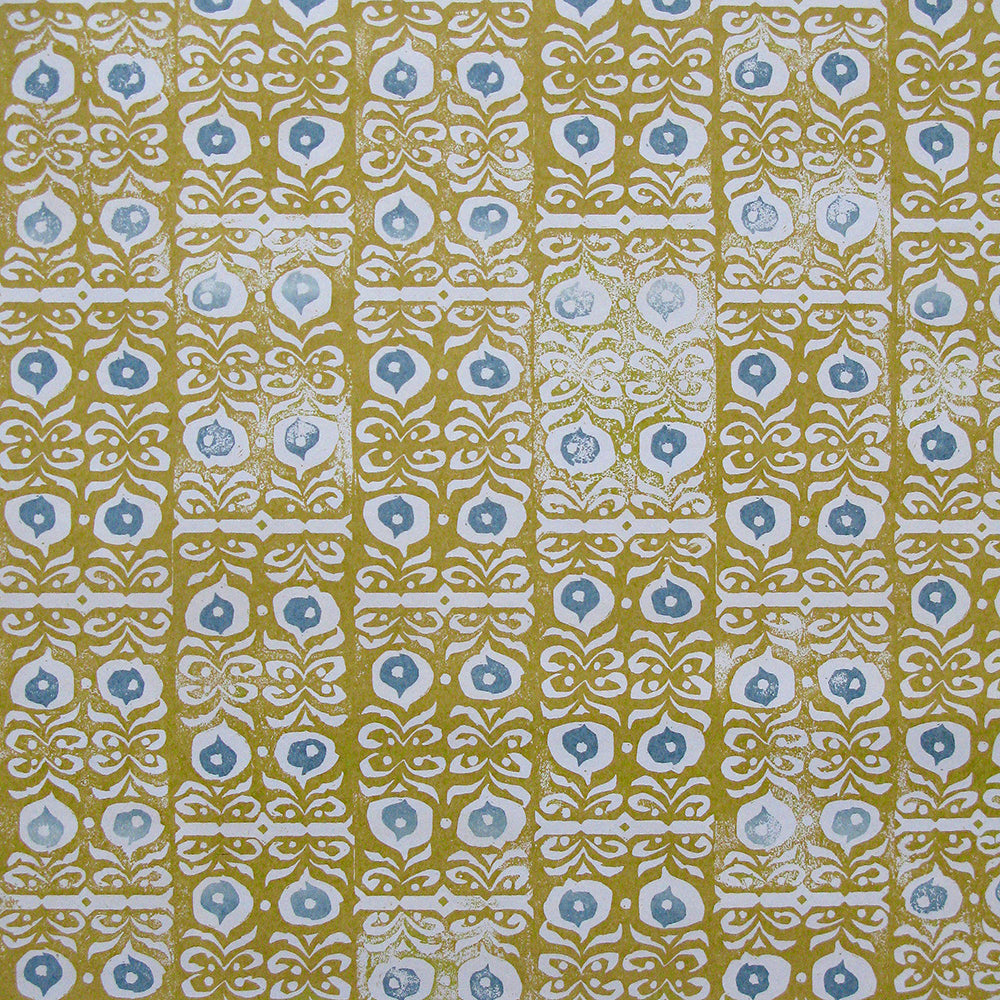 Wallpaper in a repeating damask print in blue and white on a mustard field.